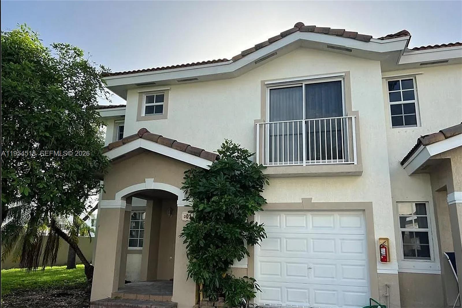 13990 Southwest 260th Street, Unit 13990 Homestead, FL 33032 - Photo 3 of 33 a front view of a house with garden