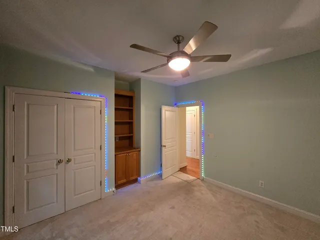 an empty room with closet and fan