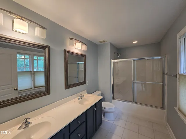 a bathroom with a sink mirror and a shower