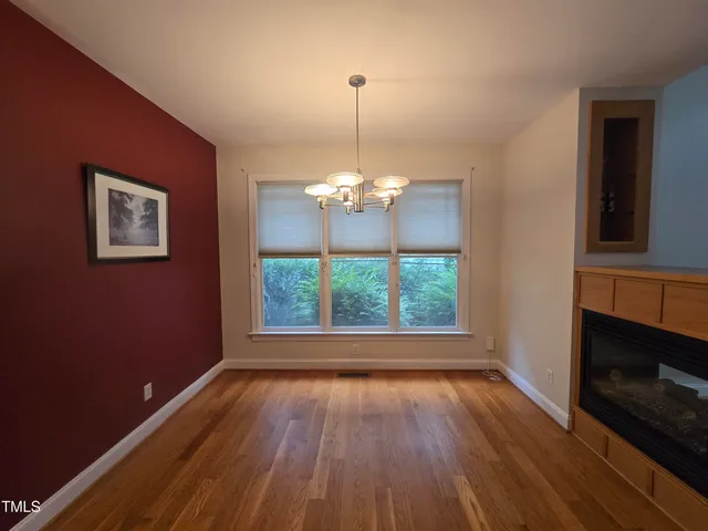 a view of a room with wooden floor fireplace and chandelier
