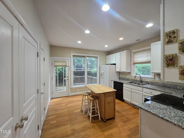 a large kitchen with granite countertop a large counter top space and stainless steel appliances
