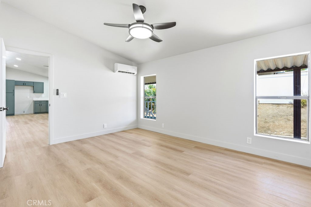 15181 Van Buren, Unit 262 Riverside, CA 92504 - Photo 22 of 48 an empty room with wooden floor chandelier fan and windows