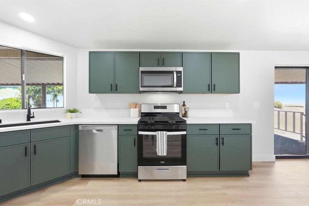 15181 Van Buren, Unit 262 Riverside, CA 92504 - Photo 4 of 48 a kitchen with stainless steel appliances granite countertop a stove a sink and a microwave