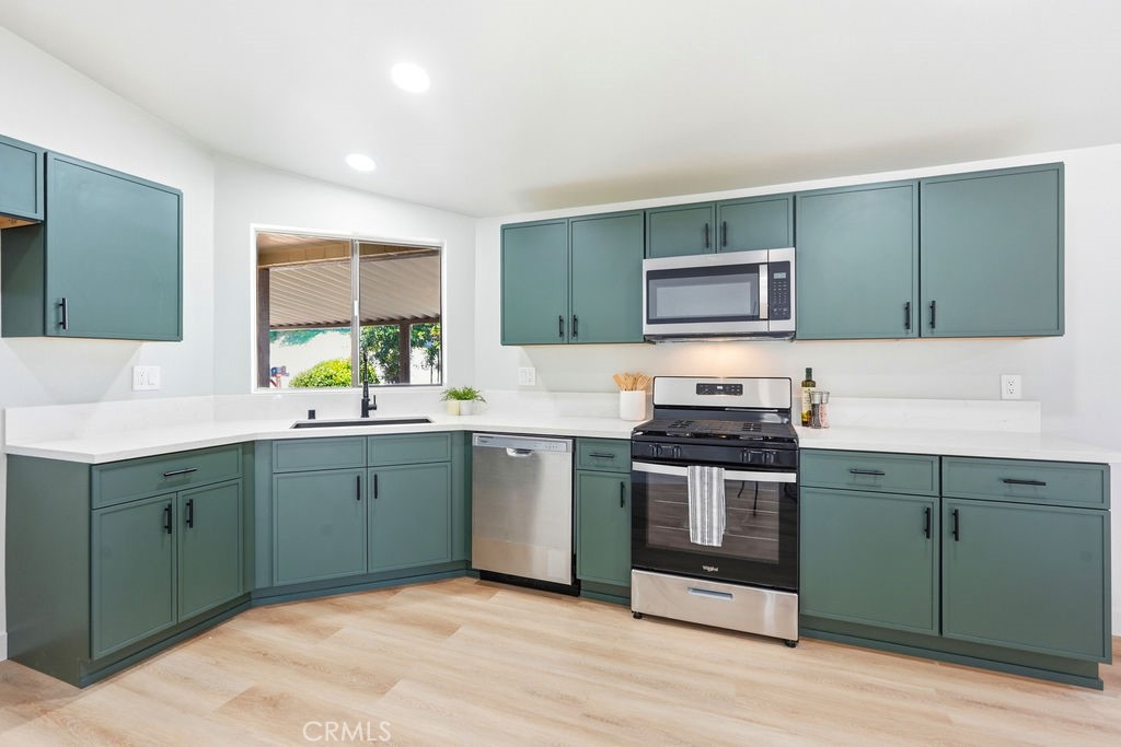 15181 Van Buren, Unit 262 Riverside, CA 92504 - Photo 6 of 48 a kitchen with stainless steel appliances granite countertop a stove a sink and a microwave