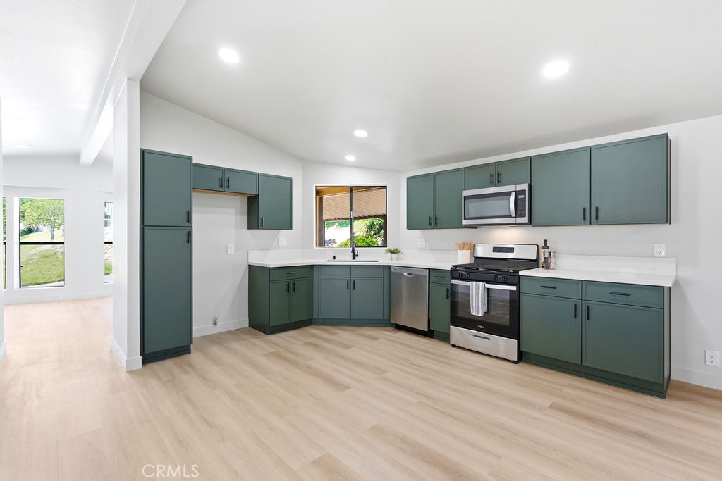 15181 Van Buren, Unit 262 Riverside, CA 92504 - Photo 8 of 48 a kitchen with a refrigerator sink and wooden cabinets
