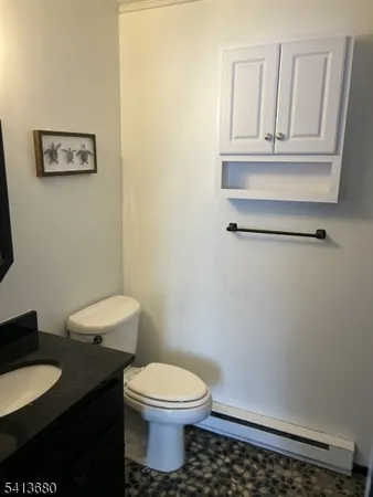 a bathroom with a toilet a sink and mirror
