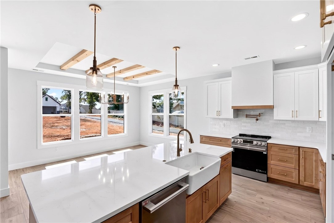 416 Blume Road Anderson, SC 29625 - Photo 9 of 29 A contemporary kitchen space boasts an inviting island with a farmhouse sink, perfectly illuminated by stylish pendant lighting.