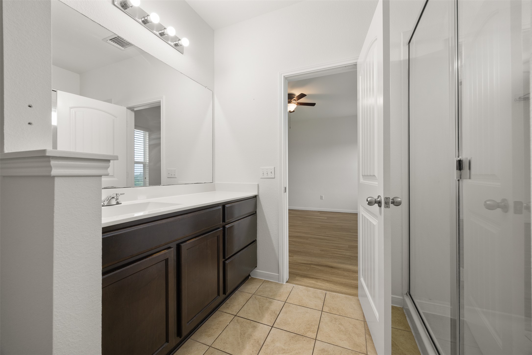 703 Liard River Road Hutto, TX 78634 - Photo 10 of 16 A well-appointed vanity with generous counter space, a large mirror, and warm tile flooring offers a comfortable and practical bathing area.