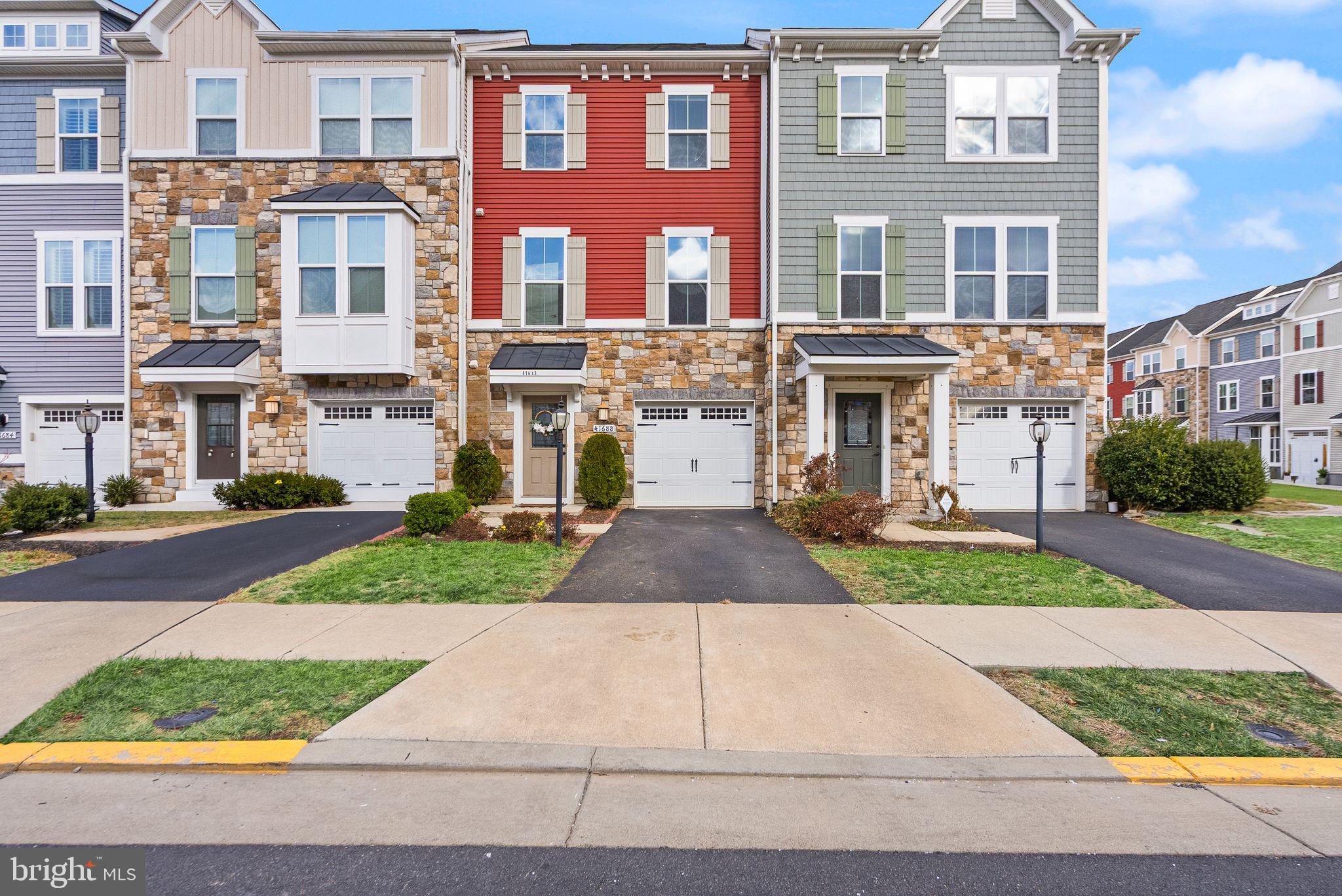 41688 McMonagle Square Aldie, VA 20105 - Photo 5 of 59 a front view of a house with a yard and garage