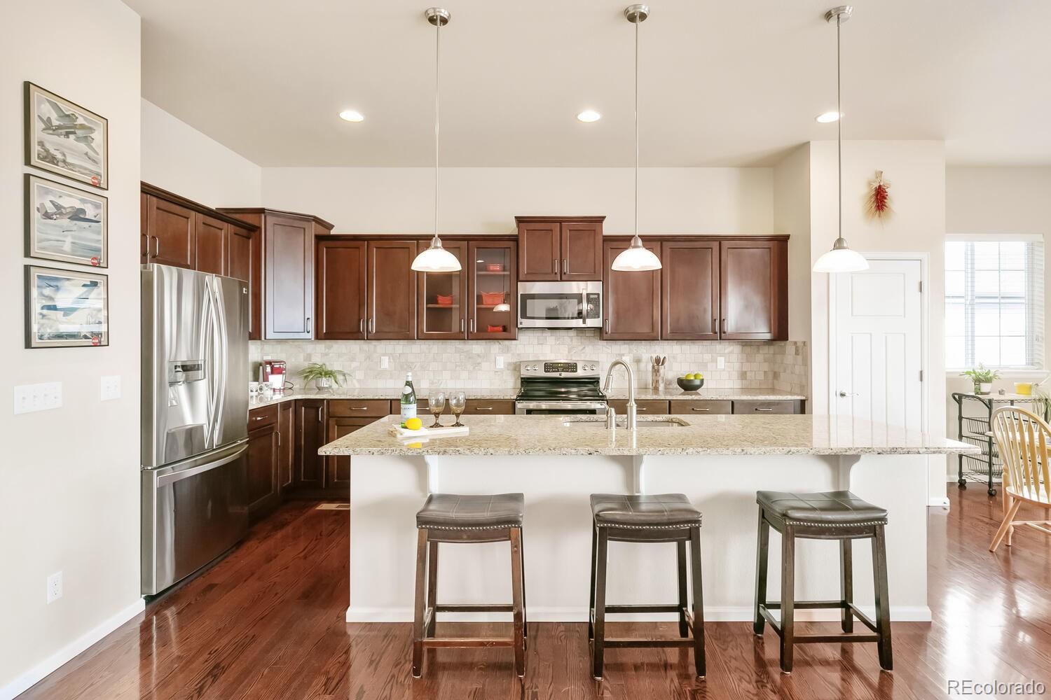 a kitchen with refrigerator a sink and chairs