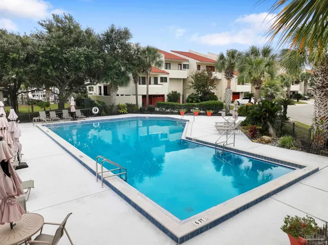 a view of swimming pool with outdoor seating and a garden