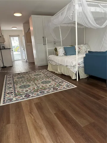 a bedroom with a bed a rug and a large window