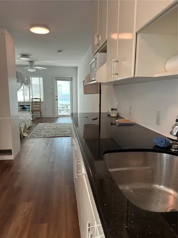 a kitchen with granite countertop a sink a stove and cabinets