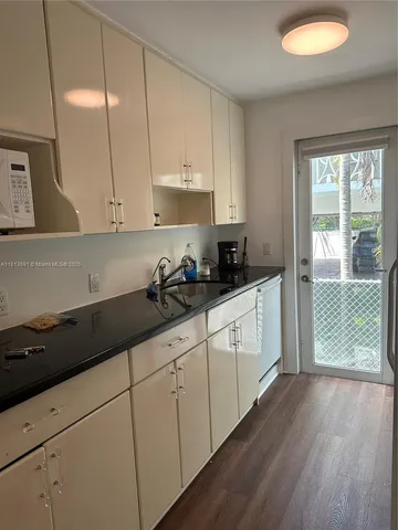 a kitchen with granite countertop white cabinets and white appliances