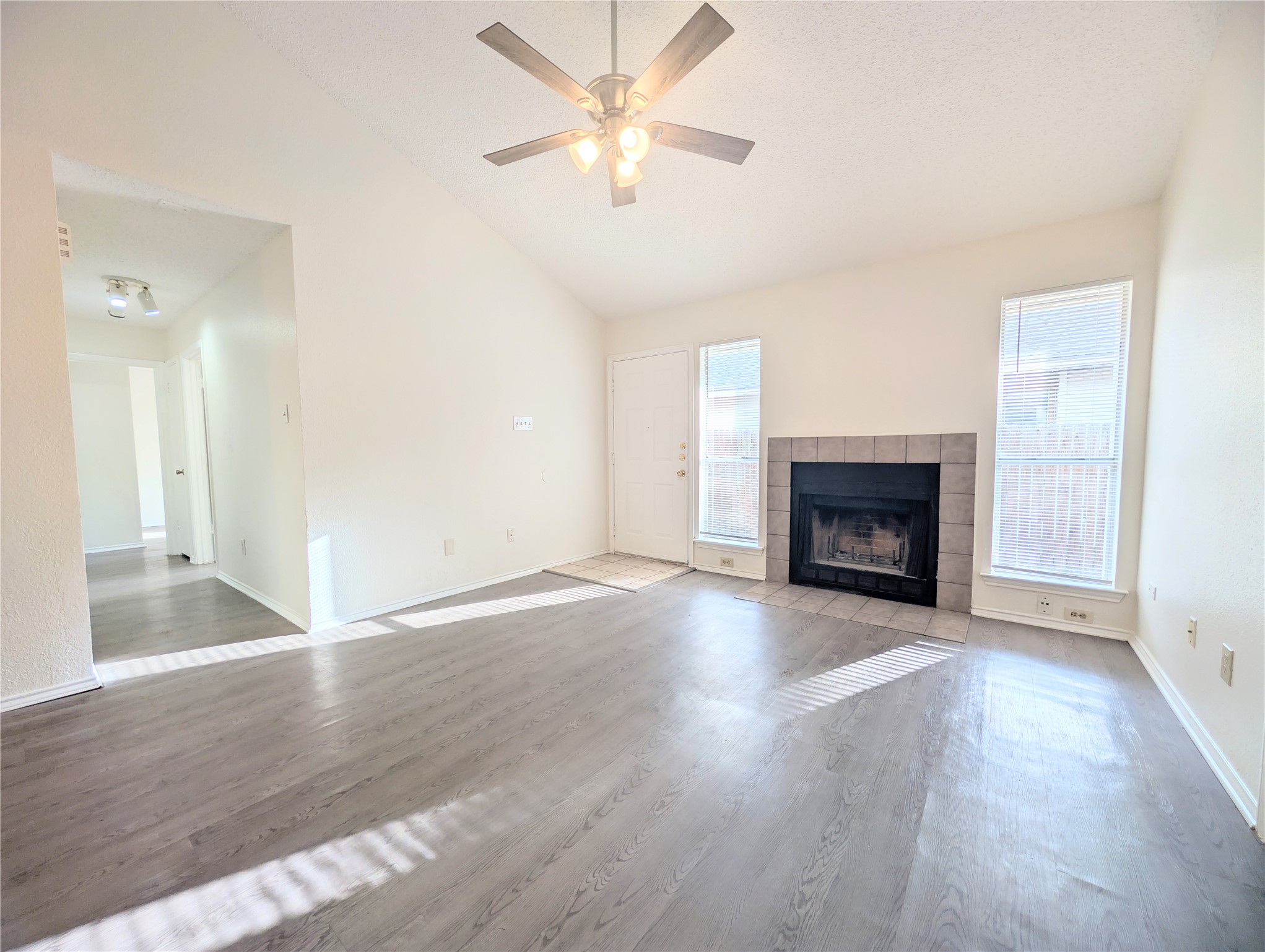 2016 Redwing Way Round Rock, TX 78664 - Photo 4 of 19 A welcoming living space features lofty vaulted ceilings and a charming fireplace, all atop rich hardwood flooring.