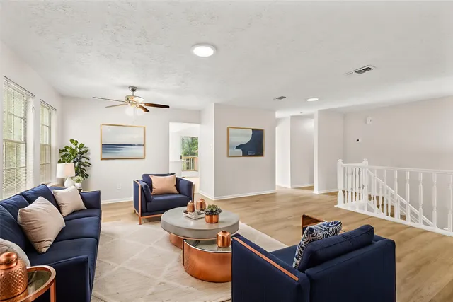 a living room with furniture and a wooden floor