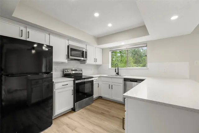 a kitchen with stainless steel appliances granite countertop a stove a sink and a microwave