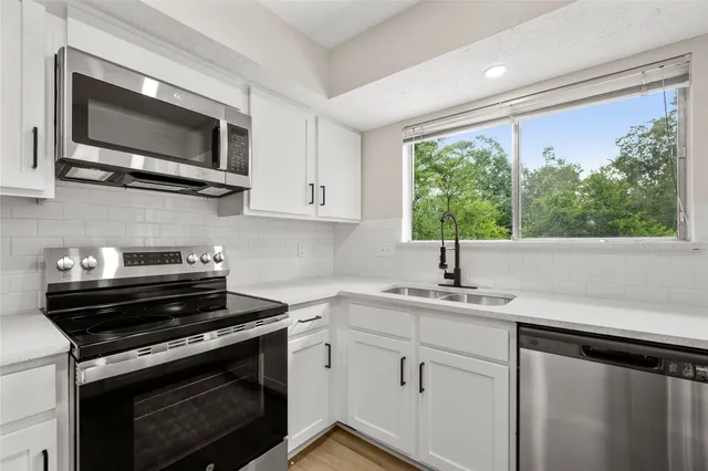 a kitchen with a sink stove and microwave