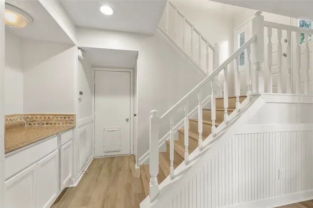 a view of hallway with stairs and wooden floor