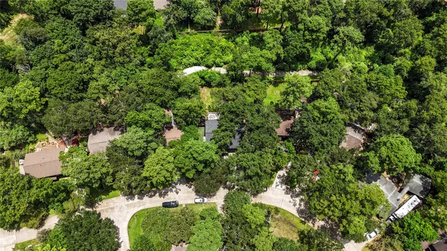 a front view of a house with a large tree