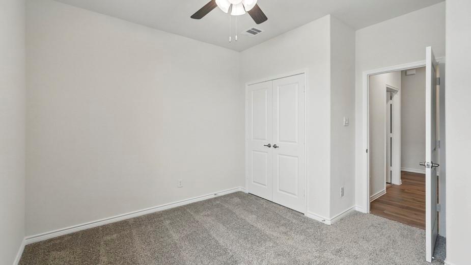 4162 Waldron Trail Forney, TX 75126 - Photo 25 of 29 Bedroom featuring neutral gray carpeting, white trim, a ceiling fan with light fixture, and a white double-door closet
