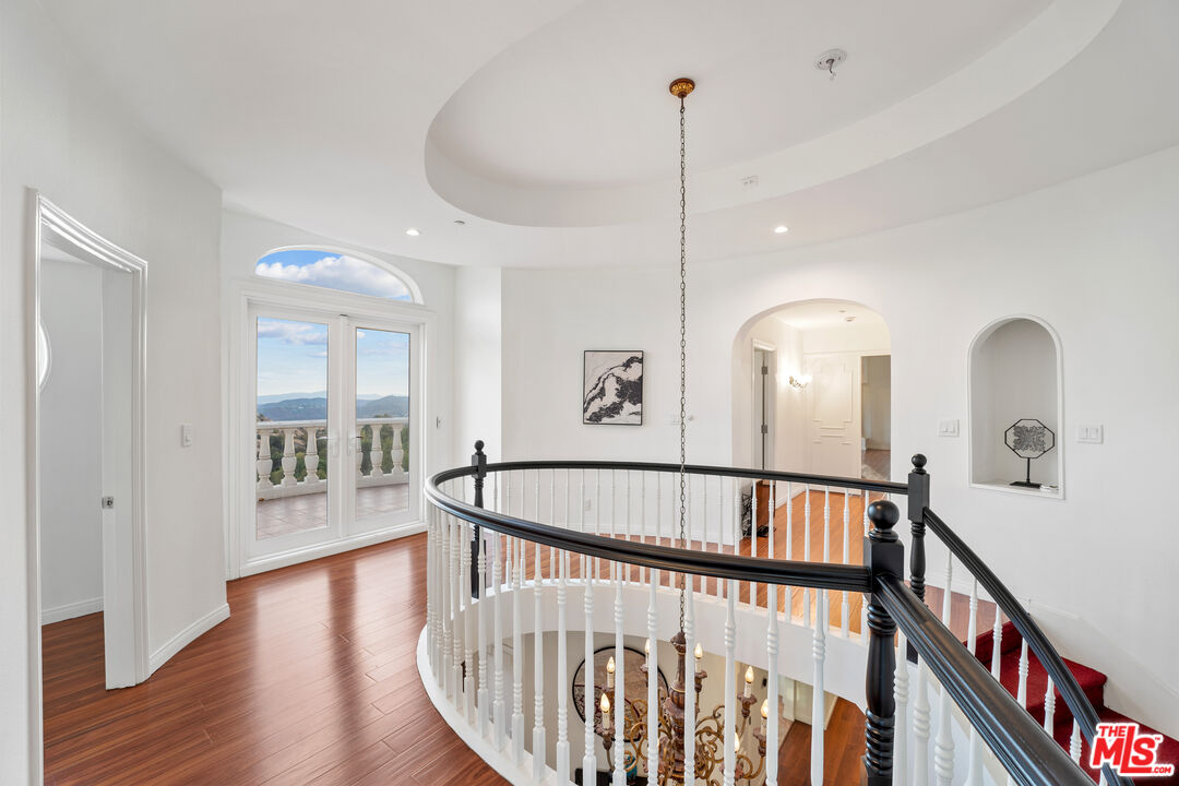 7449 Studio Road West Hills, CA 91304 - Photo 21 of 33 a view of staircase with railing and a chandelier