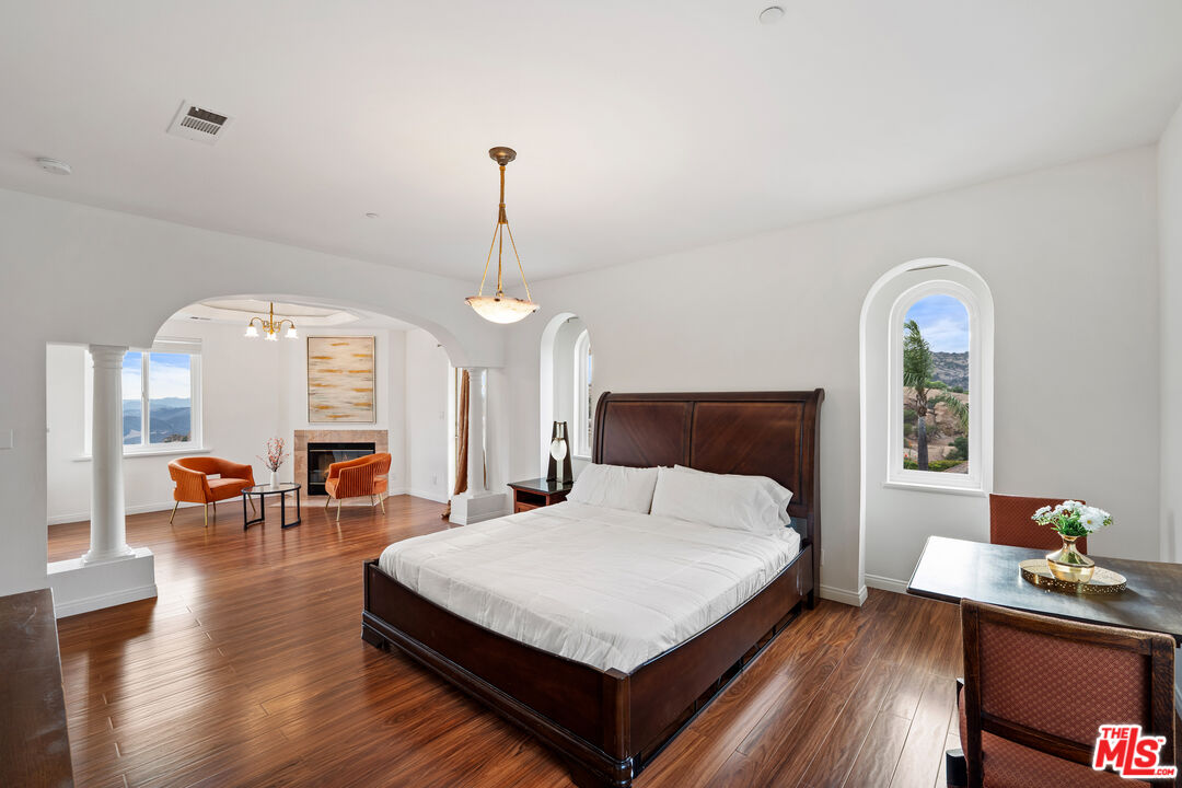 7449 Studio Road West Hills, CA 91304 - Photo 22 of 33 a spacious bedroom with a bed and wooden floor