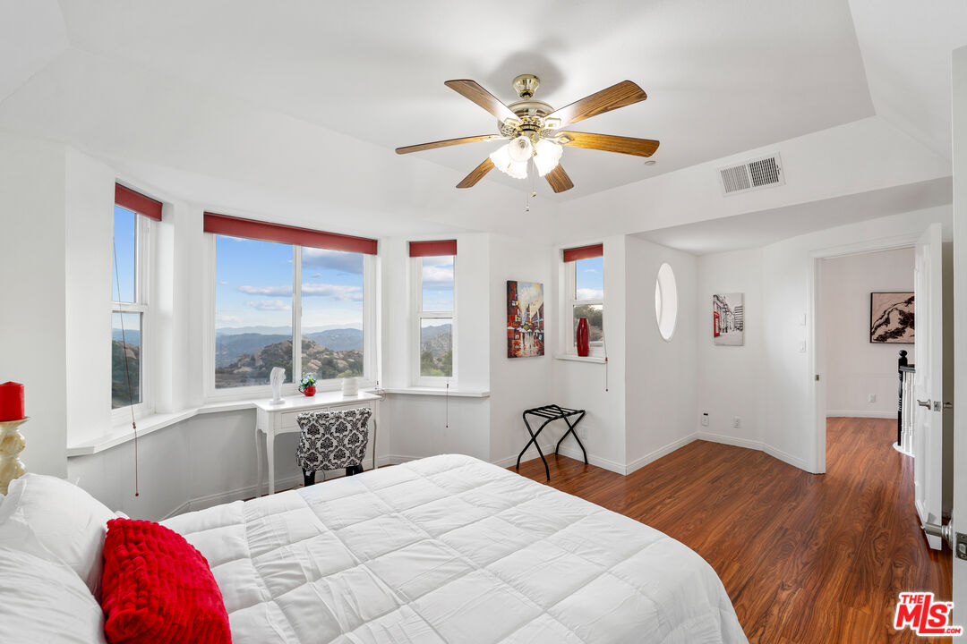 7449 Studio Road West Hills, CA 91304 - Photo 26 of 33 a bedroom with a bed and a chandelier