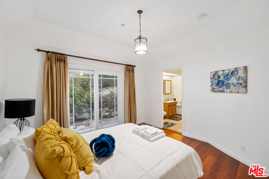 7449 Studio Road West Hills, CA 91304 - Photo 31 of 33 a bedroom with bed and glass windows