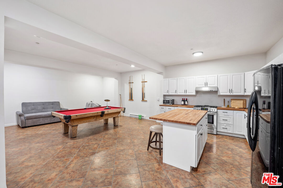 7449 Studio Road West Hills, CA 91304 - Photo 32 of 33 a living room with stainless steel appliances kitchen island granite countertop furniture and a couch