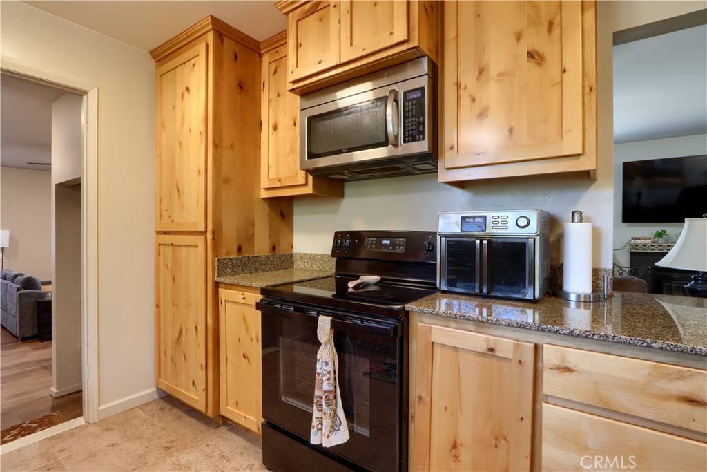 5268 Schafer Road Mariposa, CA 95338 - Photo 13 of 45 a kitchen with stainless steel appliances granite countertop a stove microwave and cabinets
