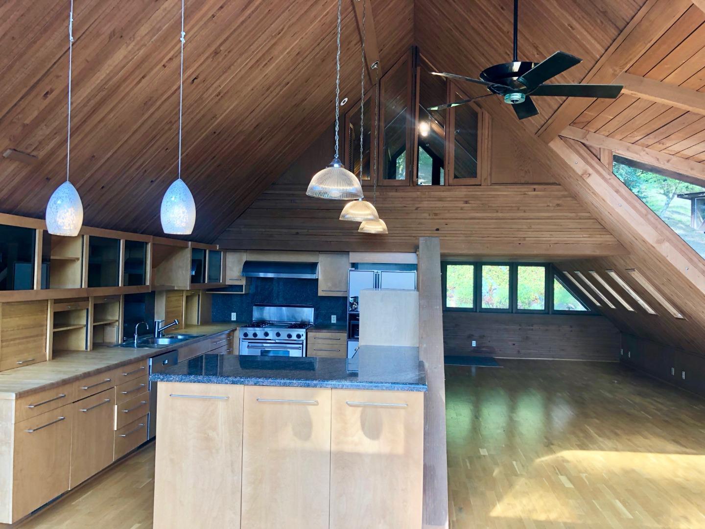 87 Upenuf Road Woodside, CA 94062 - Photo 11 of 42 a view of a living room with kitchen island stainless steel appliances table chairs and a fireplace