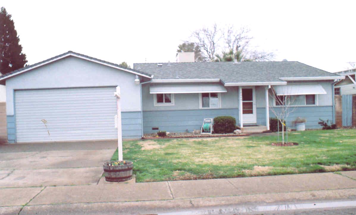 a view of a house with a yard and a garage