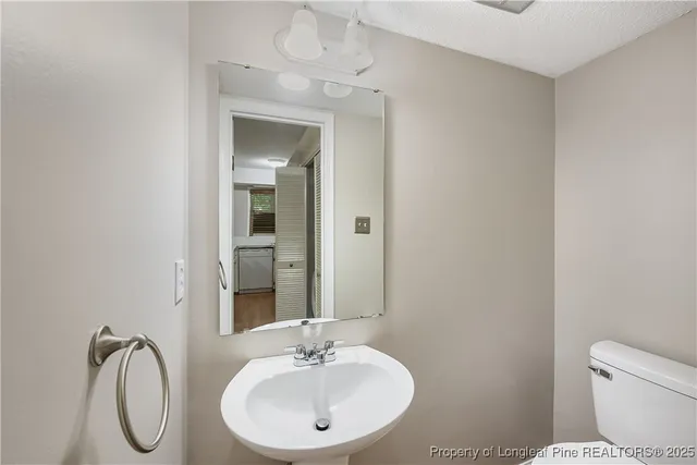 a bathroom with a sink toilet and mirror