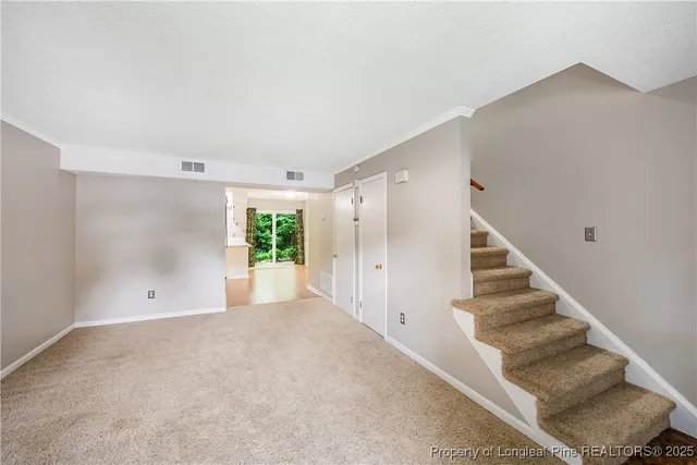 a view of a big room with staircase and white walls