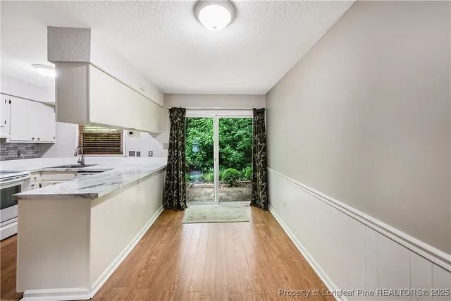 a kitchen with a sink and wooden floor