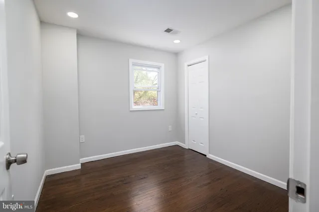 an empty room with wooden floor and a window