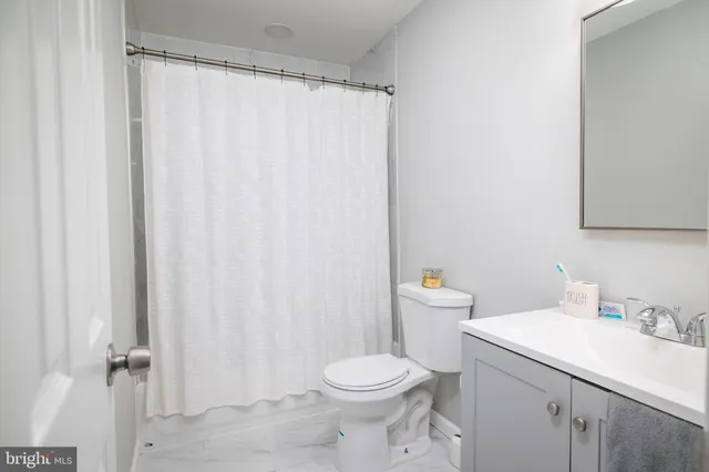 a bathroom with a sink a toilet and shower curtain