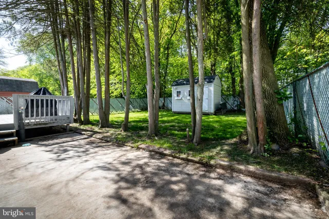a view of a house with backyard and a trees