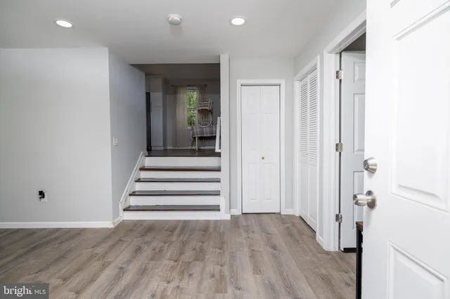 a view of a hallway with wooden floor and staircase