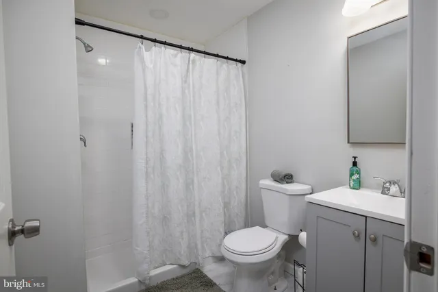 a bathroom with a sink a toilet and shower curtain