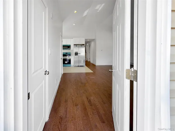 a view of a hallway with wooden floor and staircase