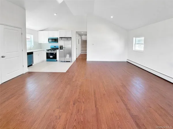 a view of kitchen with cabinets wooden floor and stainless steel appliances