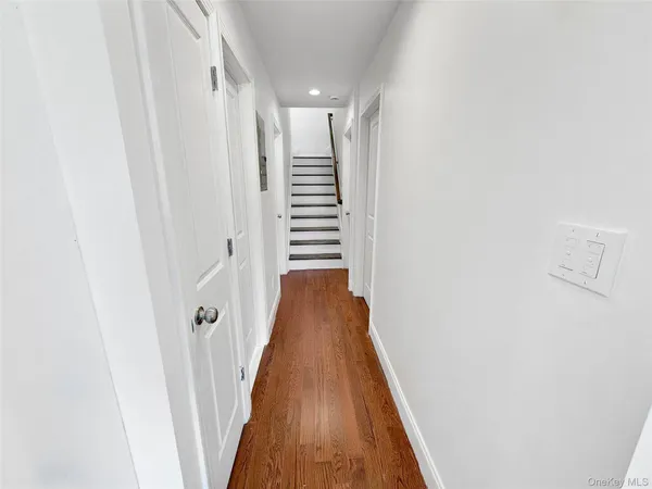 a view of a hallway with wooden floor and stairs