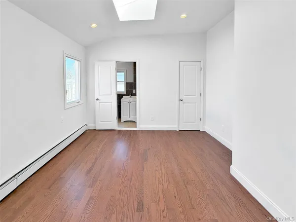 an empty room with wooden floor & windows