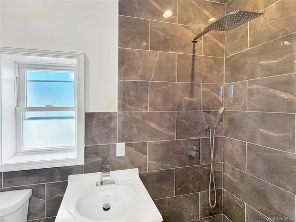 a bathroom with a sink a window and shower
