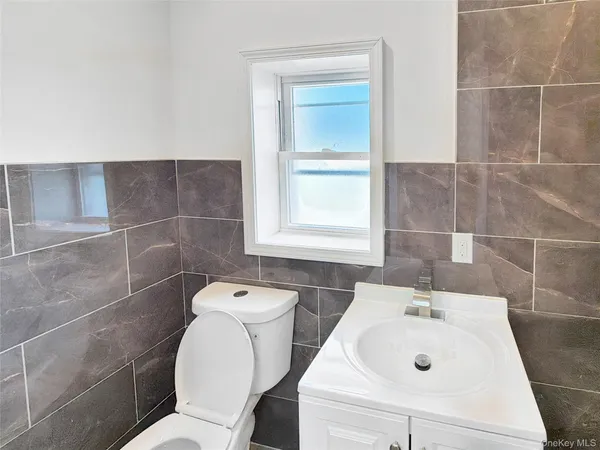 a bathroom with a sink a toilet and a mirror