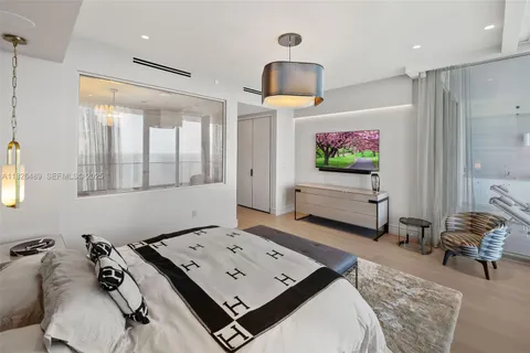 a spacious bedroom with a large bed and large windows