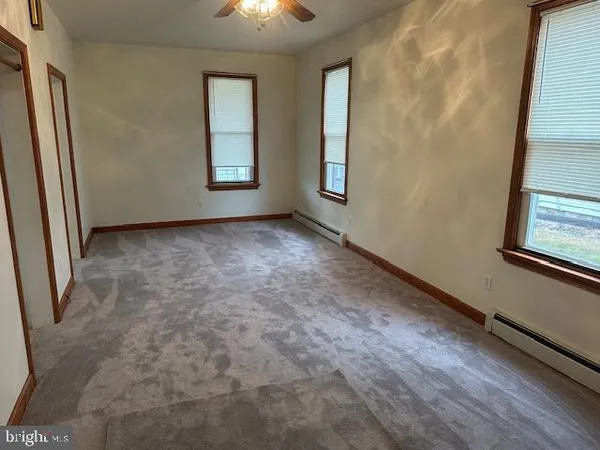 an empty room with windows and closet