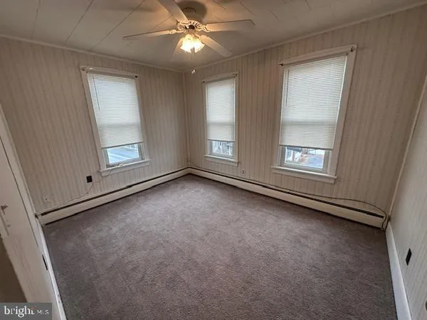 an empty room with windows and closet